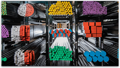 Close up
            of the ends metal cylinders stacked on-top of one-another in a
            warehouse