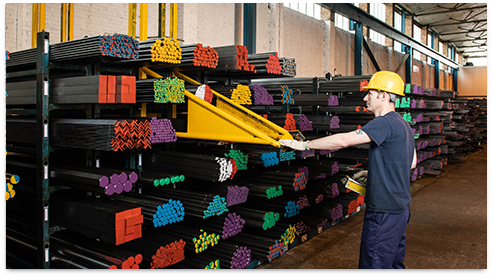 Close up
            of the ends metal cylinders stacked on-top of one-another in a
            warehouse